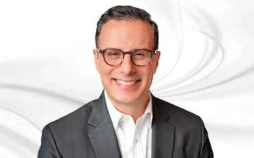 Nicholas Mitrakis headshot on white marble backround